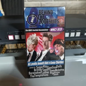 Front of Behind the Zootsuits VHS case with WNCI 97.9 branding, three pictured presenters and advertised music-act cameos