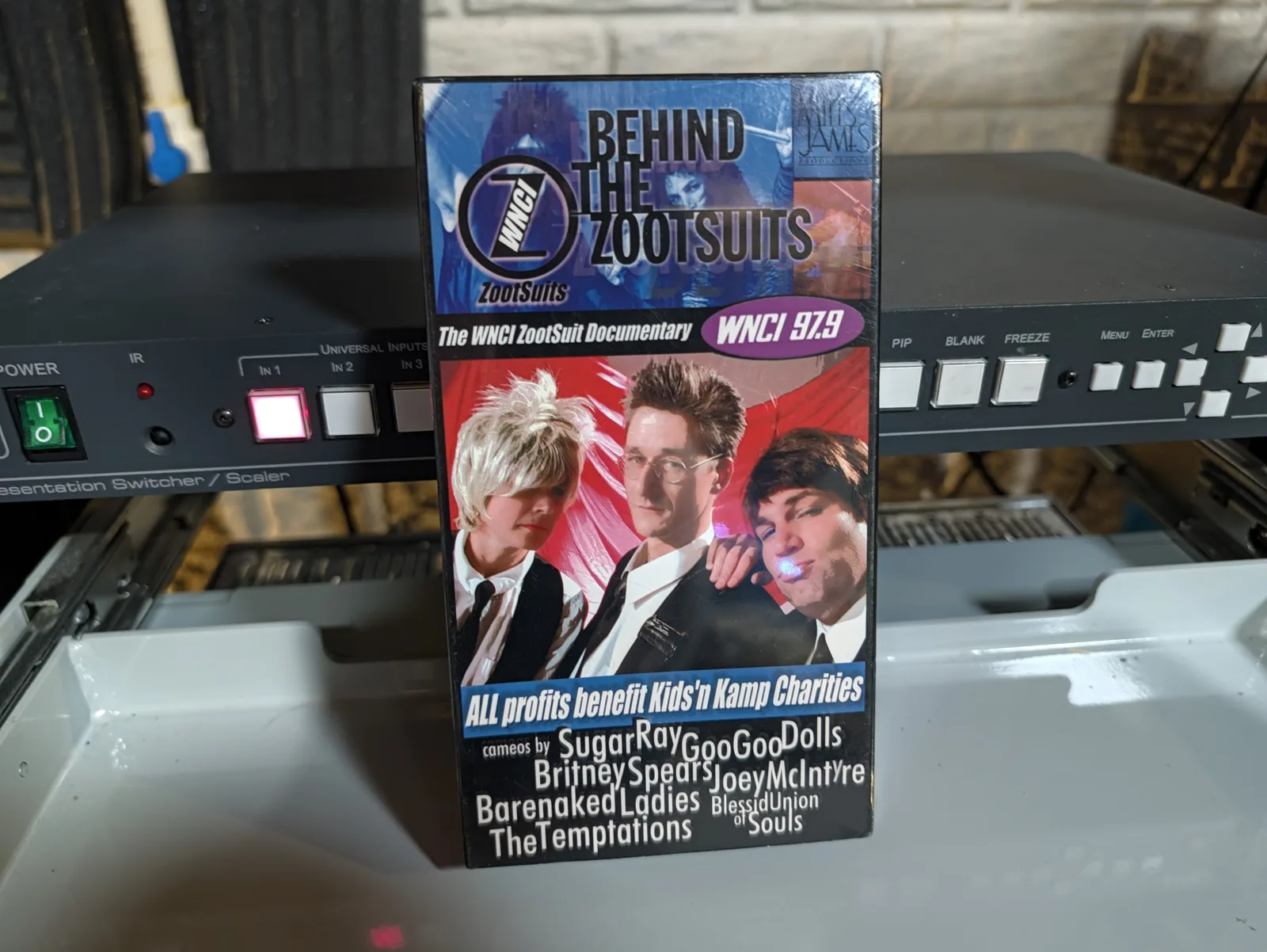 Front of Behind the Zootsuits VHS case with WNCI 97.9 branding, three pictured presenters and advertised music-act cameos
