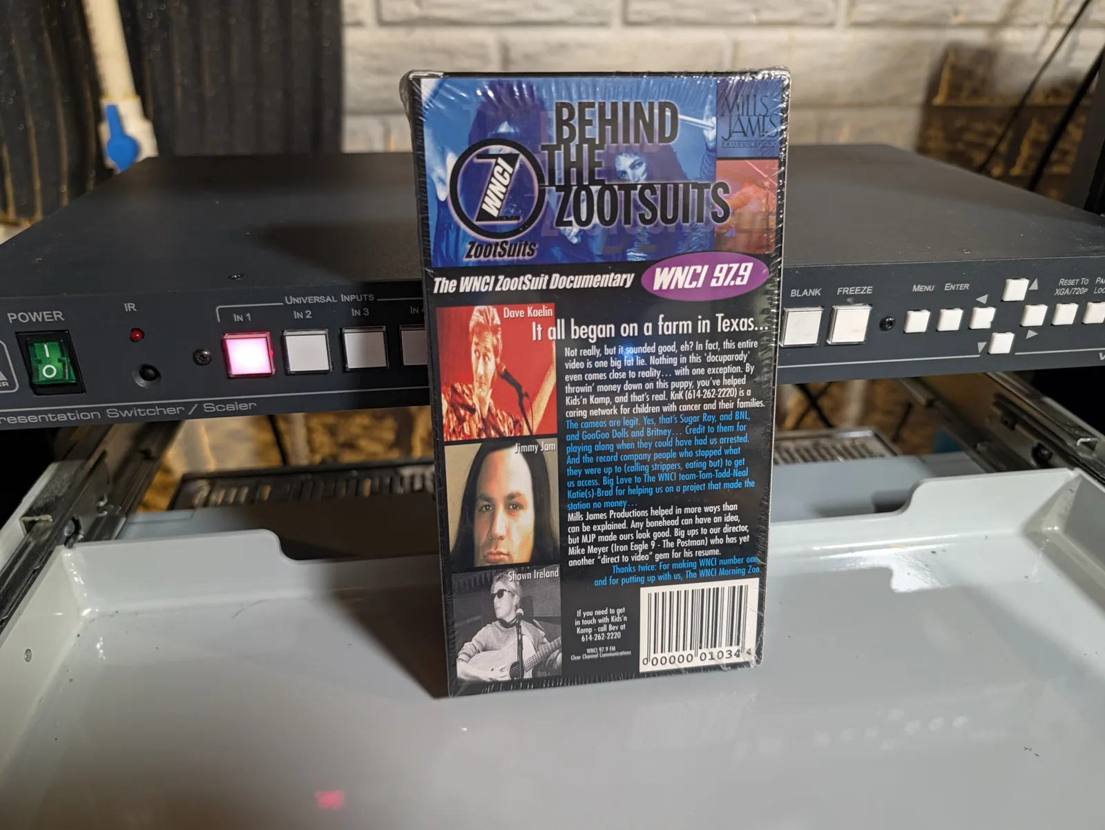 Back of Behind the Zootsuits VHS case with presenter portraits, credits and a printed charity contact number