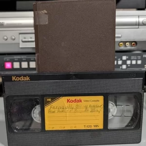 Kodak VHS with handwritten program label and brown sleeve.