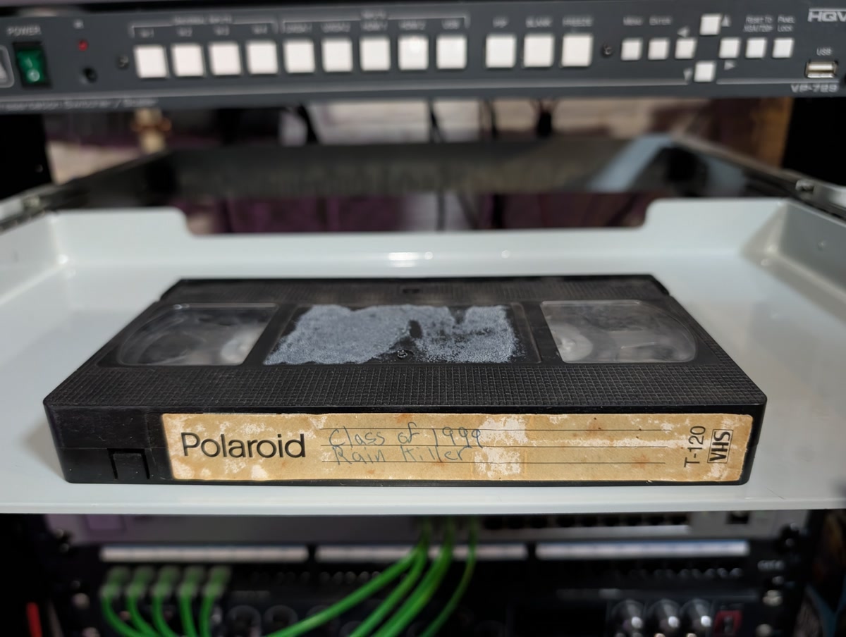 Polaroid T-120 labeled Class of 1999 and Rain Killer but actually holding early Simpsons with commercials (VHS-2026-255)