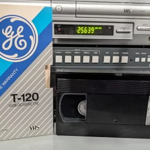 GE T-120 VHS tape in front of its blue-and-silver GE Lifetime Warranty sleeve.