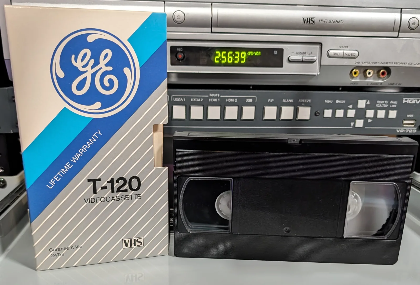 GE T-120 VHS tape in front of its blue-and-silver GE Lifetime Warranty sleeve.