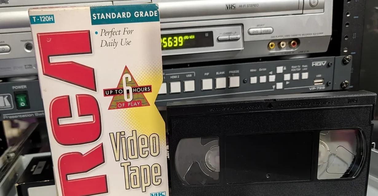 VHS cassette beside a T-120H Standard Grade sleeve; both extend below the cropped frame.