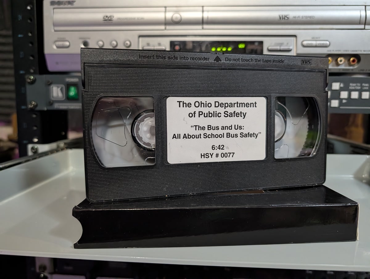 Black clamshell VHS of The Bus and Us. Ohio school bus safety film, Dept. of Public Safety, government-issued (VHS-2026-276)
