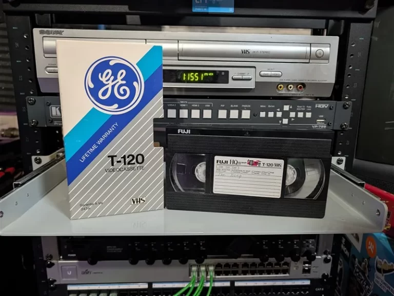 Fuji HQ T-120 VHS with faint handwritten label beside a mismatched GE T-120 Lifetime Warranty sleeve.