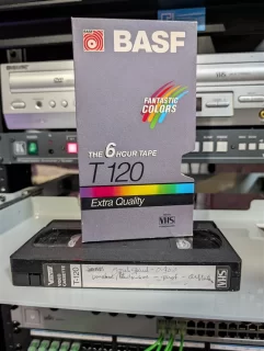 T-120 VHS with faint handwritten spine label in front of a mismatched BASF Fantastic Colors sleeve.