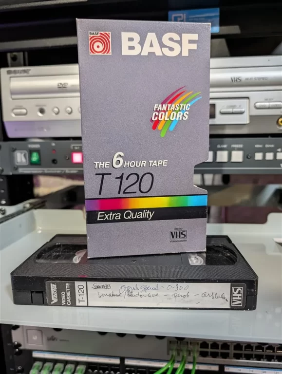 T-120 VHS with faint handwritten spine label in front of a mismatched BASF Fantastic Colors sleeve.